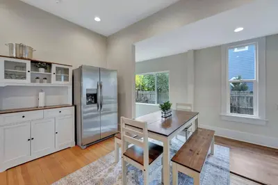 a kitchen with a wooden table and a refrigerator at Longmont 2BD Comfort | Outdoor dining + Parking in Longmont