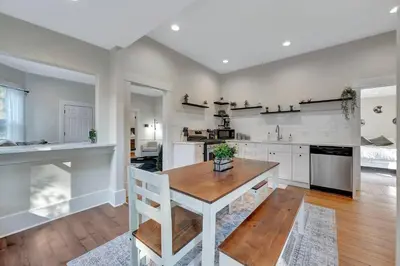 a kitchen with a wooden table and a dining room at Longmont 2BD Comfort | Outdoor dining + Parking in Longmont