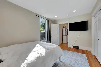 a bedroom with a bed and a flat screen tv at Longmont 2BD Comfort | Outdoor dining + Parking in Longmont