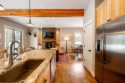 a kitchen with a stainless steel refrigerator and a living room at Winter Park Getaway 4 BR Townhouse w Hot Tub in Fraser