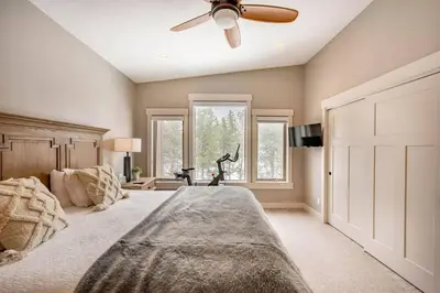 a bedroom with a large bed with a ceiling fan at Winter Park Getaway 4 BR Townhouse w Hot Tub in Fraser