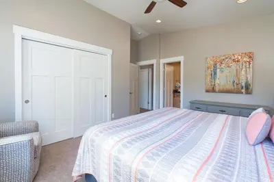 a bedroom with a bed and a painting on the wall at 4BR Fraser Getaway Hot Tub Sleeps 10 in Fraser