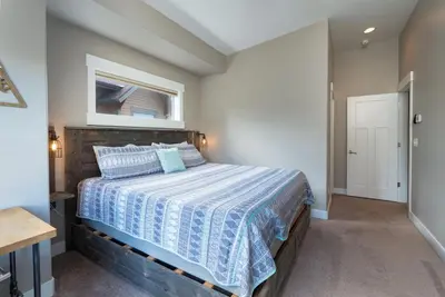 a bedroom with a bed with a blue and white comforter at 4BR Fraser Getaway Hot Tub Sleeps 10 in Fraser