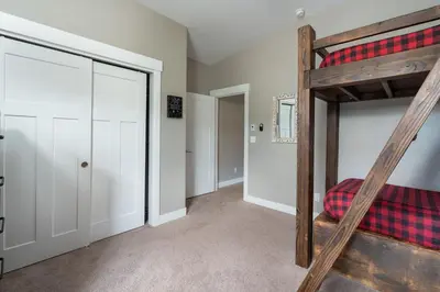 a bedroom with a bunk bed and a closet at 4BR Fraser Getaway Hot Tub Sleeps 10 in Fraser