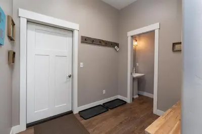 a hallway with a white door and a bathroom at 4BR Fraser Getaway Hot Tub Sleeps 10 in Fraser