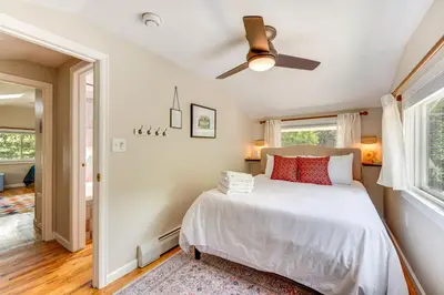 a bedroom with a bed and a ceiling fan at Private Hot Tub - Riverfront Cabin In Estes Park! in Estes Park