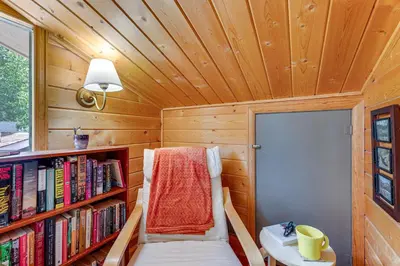 a small room with a book shelf and a bed at Private Hot Tub - Riverfront Cabin In Estes Park! in Estes Park