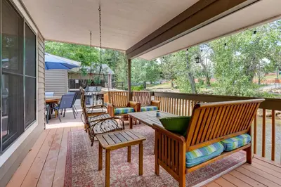 a screened in porch with chairs and a table at Private Hot Tub - Riverfront Cabin In Estes Park! in Estes Park
