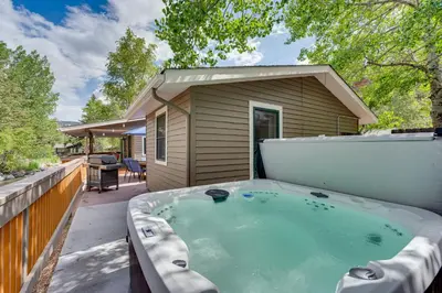 a hot tub on the patio of a house at Private Hot Tub - Riverfront Cabin In Estes Park! in Estes Park