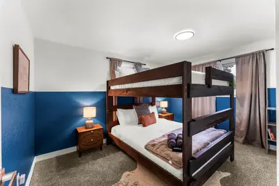 a bedroom with two bunk beds and blue walls at The Timberline- Game Room, Outdoor Theater, Bocce, Fire Pit, Pets in Arvada
