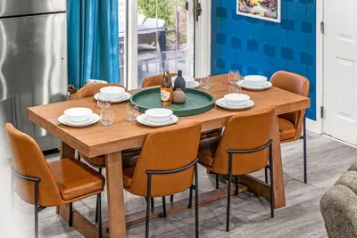 a dining room table with chairs and a bottle of wine at The Timberline- Game Room, Outdoor Theater, Bocce, Fire Pit, Pets in Arvada