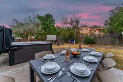a table with plates and wine glasses on a patio at The Timberline- Game Room, Outdoor Theater, Bocce, Fire Pit, Pets in Arvada
