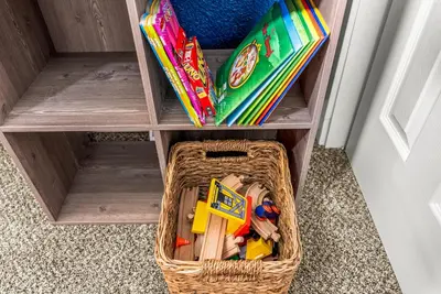 a basket filled with toys in a shelf at The Timberline- Game Room, Outdoor Theater, Bocce, Fire Pit, Pets in Arvada
