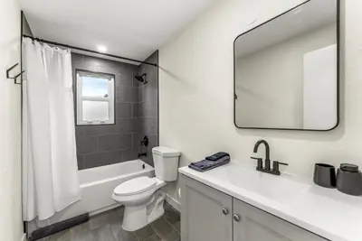 a bathroom with a toilet and a sink and a mirror at The Timberline- Game Room, Outdoor Theater, Bocce, Fire Pit, Pets in Arvada