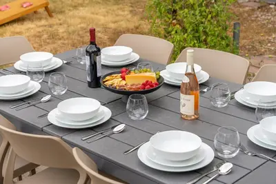 a table with white plates and a bowl of food and wine at The Timberline- Game Room, Outdoor Theater, Bocce, Fire Pit, Pets in Arvada