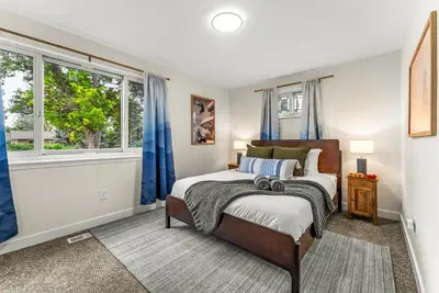 a bedroom with a bed and two windows at The Timberline- Game Room, Outdoor Theater, Bocce, Fire Pit, Pets in Arvada