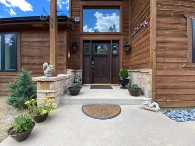 a front door of a house with a wooden wall at Echo Hills Mountain Lodge - Evergreen Mountain Top Retreat - Foothills of the Rockies in Evergreen
