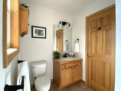 a bathroom with a toilet and a sink and a mirror at Echo Hills Mountain Lodge - Evergreen Mountain Top Retreat - Foothills of the Rockies in Evergreen