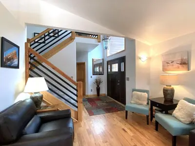 a living room with a couch and a staircase at Echo Hills Mountain Lodge - Evergreen Mountain Top Retreat - Foothills of the Rockies in Evergreen