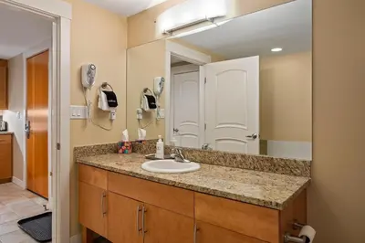 a bathroom with a sink and a large mirror at Fraser Crossing cabin in Winter Park