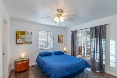 a bedroom with a blue bed and a ceiling fan at Modern Getaway with Private Balcony in Denver