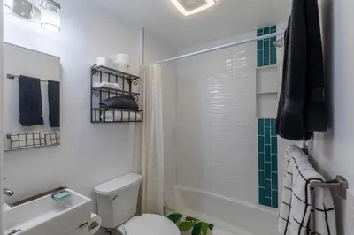 a white bathroom with a toilet and a shower at Modern Getaway with Private Balcony in Denver