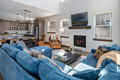 a living room with a blue couch and a fireplace at Aspen View Chalet home in Fraser