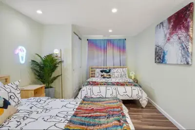 a bedroom with two beds and a painting on the wall at The Denver Duo Two Homes, One Epic Stay in Denver