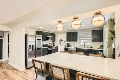 a kitchen with a large white counter top and chairs at The Denver Duo Two Homes, One Epic Stay in Denver