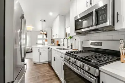 a kitchen with a stove and a microwave at West Denver Radiance Light and Bright 3BR retreat in Denver