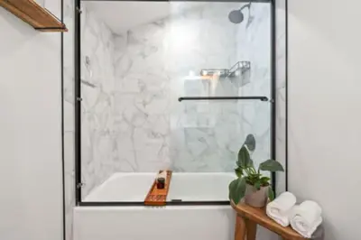a bathroom with a shower with a white tub at West Denver Radiance Light and Bright 3BR retreat in Denver