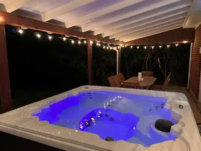 a jacuzzi tub on a patio with lights at Cozy Hot Tub Escape - Pool Table & Home Theater in Arvada