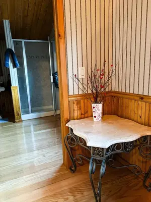 a table with a vase on it in a room at The Carriage House, Walk to River & Lake, In Town in Grand Lake