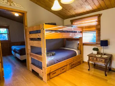 a bedroom with two bunk beds in a cabin at The Carriage House, Walk to River & Lake, In Town in Grand Lake
