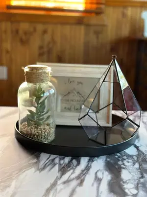 a glass jar with a plant in it next to a scale at The Carriage House, Walk to River & Lake, In Town in Grand Lake