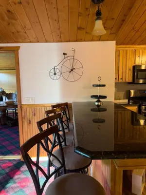 a kitchen with a table with a bike on the wall at The Carriage House, Walk to River & Lake, In Town in Grand Lake