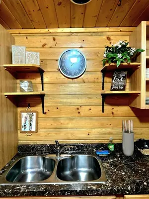 a kitchen with a sink and a clock on a wall at The Red Bears Den, Walk to River & Lake, In Town in Grand Lake