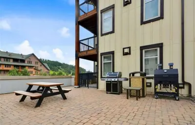 a patio with a picnic table and a grill at Winter Park Village Homebase in Winter Park