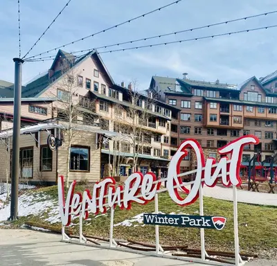 a sign for a winter park with buildings in the background at Winter Park Village Homebase in Winter Park