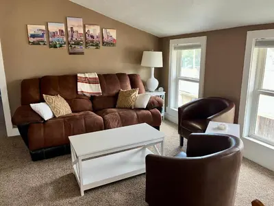 a living room with a brown couch and two chairs at Historic Home with Farm Fresh Eggs in Denver in Denver