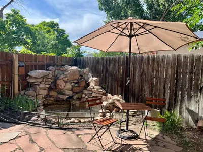 a patio with an umbrella and a table and chairs at Historic Home with Farm Fresh Eggs in Denver in Denver