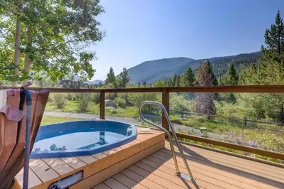 a hot tub on a deck with a view of the mountains at Frostfire B19 condo in Snake River Health Services Incorporated Heliport