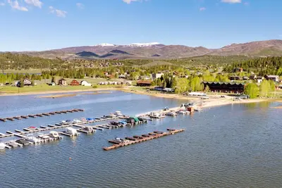 an aerial view of a marina with boats in the water at Beacon Landing Condo, Lakefront on Lake Granby, Luxurious Quality with Marina Right Outside in Grand Lake