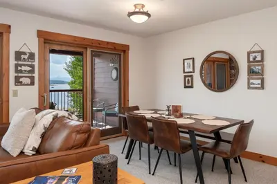 a living room with a table and a couch at Beacon Landing Condo, Lakefront on Lake Granby, Luxurious Quality with Marina Right Outside in Grand Lake
