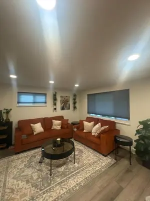 a living room with two couches and a flat screen tv at Relax & Recharge, Peaceful Home in Northglenn