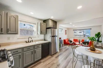 a kitchen and living room with a table and a refrigerator at Relax & Recharge, Peaceful Home in Northglenn
