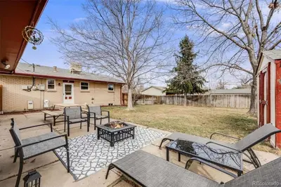 a patio with a table and chairs and a fire pit at Relax & Recharge, Peaceful Home in Northglenn
