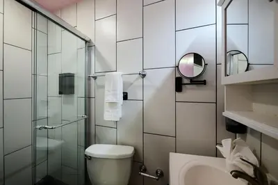 a bathroom with a toilet and a glass shower at BIG little Hotel in Denver