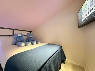 two stuffed teddy bears sitting on top of a bed at BIG little Hotel in Denver