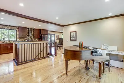 a living room with a piano and a kitchen at Pet-Friendly Retreat with Fenced Yard in Aurora in Aurora
